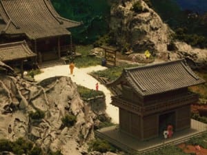 miniature human figurines inside traditional japanese houes in model railroad