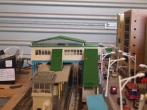 train station next to traffic in japan-themed railroad model