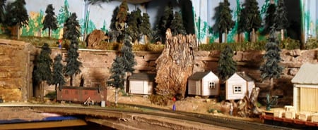 cabins and trees next to the train tracks