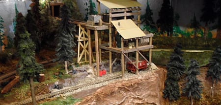 wooden structure with red wagon of model railroad