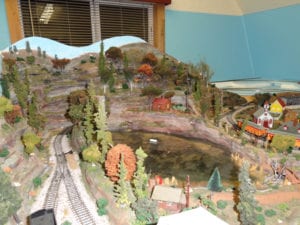 a view of the half of the model railroad with town and the cabin