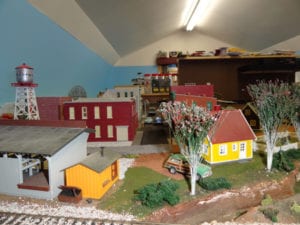 house and farm beside model train track
