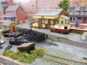 Men shoveling coal onto trucks on the model railroad.