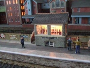 People standing by the signal box, waiting for the model train.