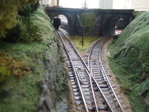 Model train passing under an arch. 