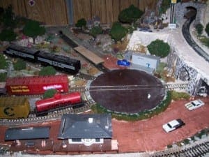 Model trains in front of railway turntable scale model.