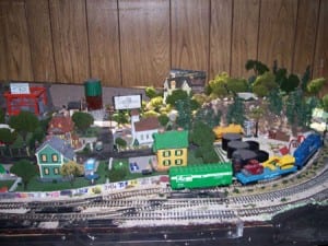 Houses and trees beside the train tracks on the model railroad layout.