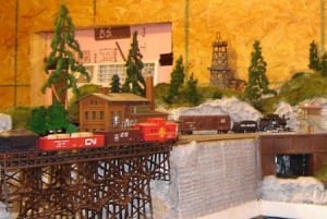 Trees by the side of a bridge on the model railroad layout.
