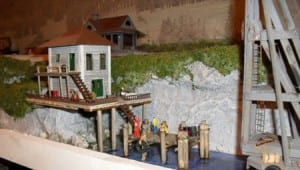 House with a deck by the water on the model railroad.
