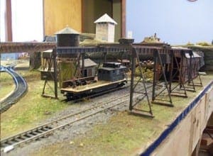 Train car beside a garage and water tower.