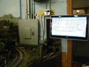 Touch screen device beside the model railroad layout.