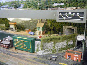 Different houses beside tunnels on the model railroad.