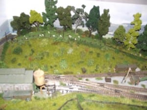 Clearing on the model train layout with garage and water tank.