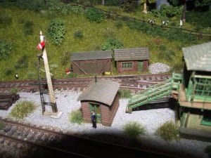 Man standing at the side of the model train track.