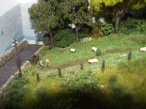 Two people walking along a path on the model railroad layout.