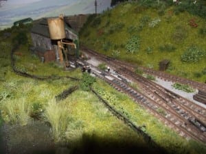A section of the model train layout where the background scenery looks very realistic. 