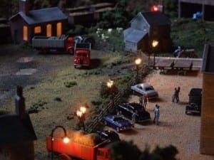 Nighttime scenery of cars parked along the fence.