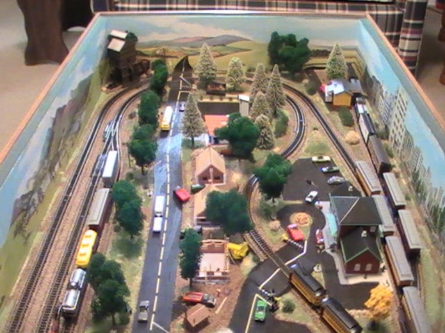 N scale coffee table model train layout with background, roads, and houses. 