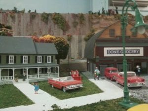 house with a family next to the grocery store on the model railroad