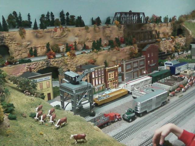 buildings, trucks, bridges, and cows of model railroad