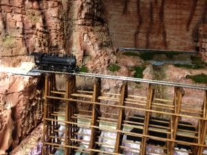 close up view of the model train crossing the wooden bridge