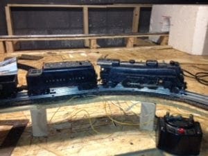 black model train sitting on a curved track of the model railroad