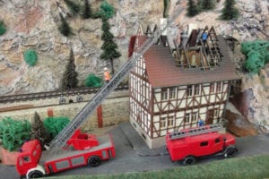 Firemen at a burned-down house on the model railroad.