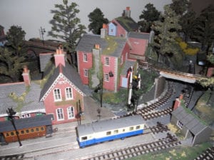 Two model trains sitting on separate tracks of the layout