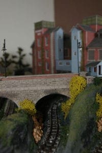 train track and ballast under a bridge arc
