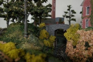 stone arch surrounded by trees on model railroad