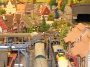 Model train moving through the city with railway signals.