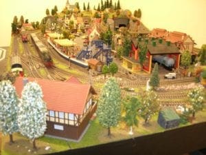 Model railroad with the houses in a backdrop of warm sunlight. 