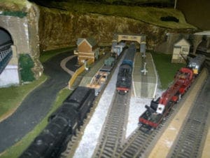 trains coming out of tunnel of model railroad
