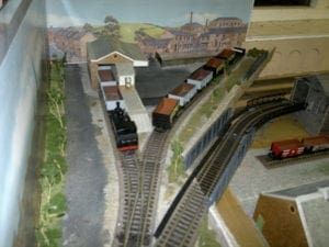 trees and body of water next to model trains