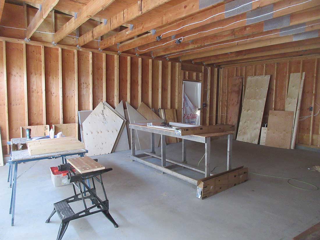Model train table sections under construction, two separate frames clamped together on a workshop floor