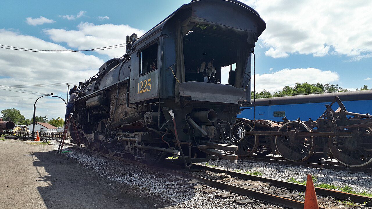 Real Pere Marquette 1225 steam locomotive with crew on a ladder beside it