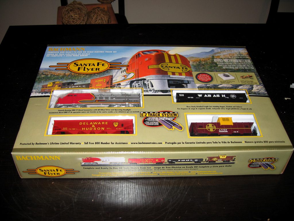 A boxed Bachmann Santa Fe Flyer HO train set sitting on a dark table