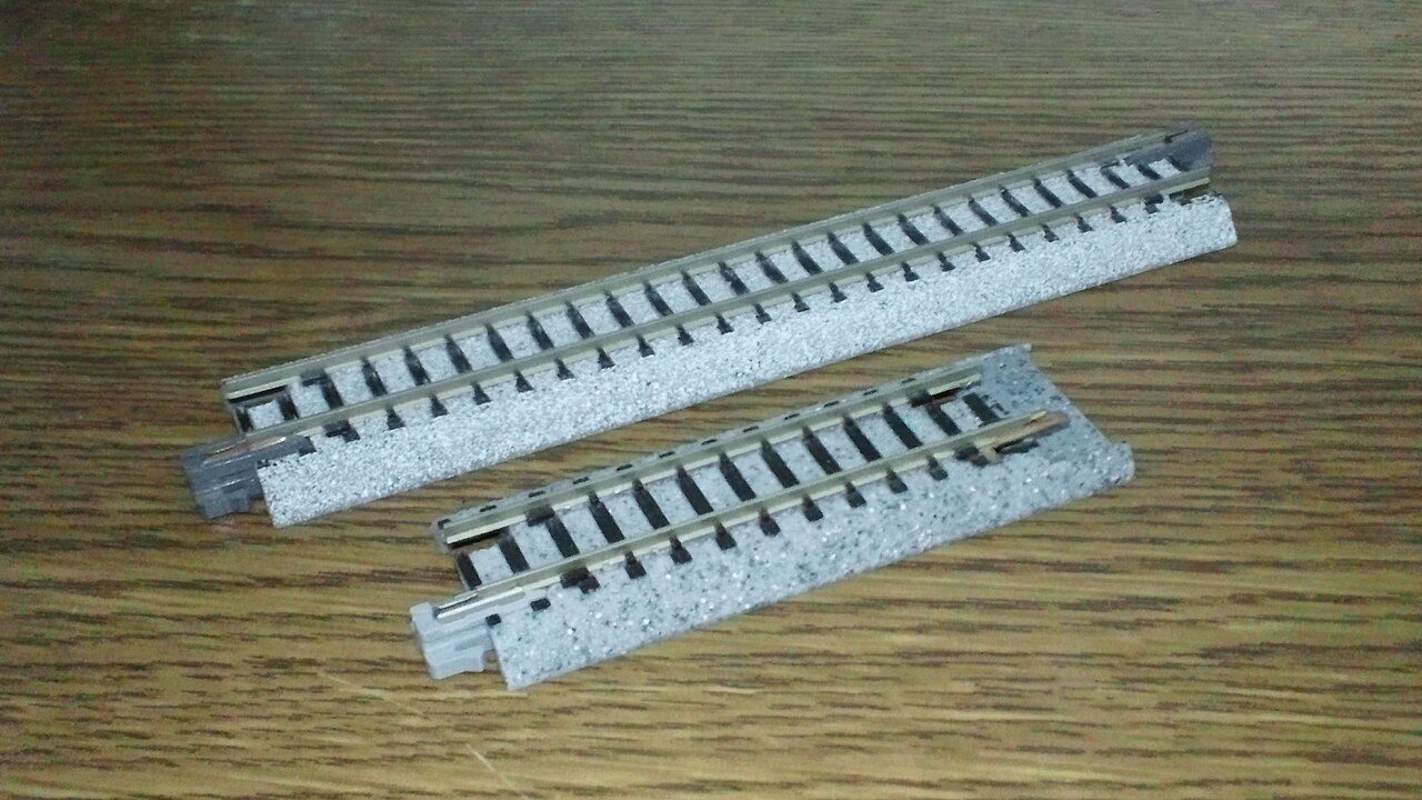 Two sections of Kato Unitrack N scale track with gray roadbed on a wooden table
