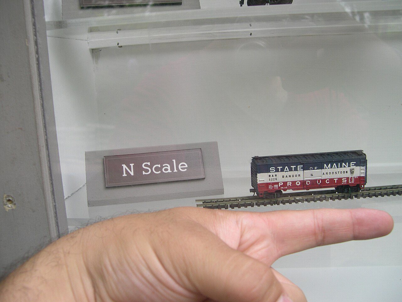 N scale boxcar on a short piece of track next to a human finger for size